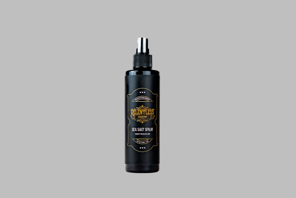 Black spray bottle with a gold label on a white background