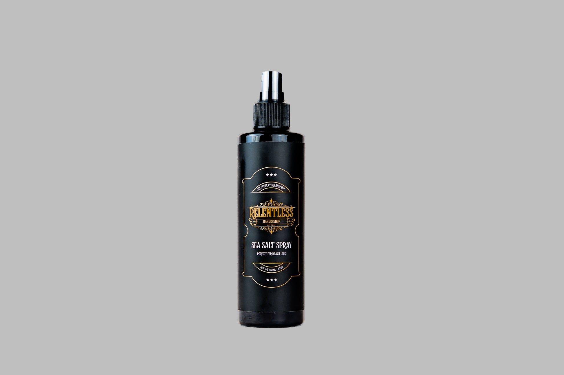 Black spray bottle with a gold label on a white background